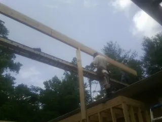 Carpenter setting a ridge beam over a new addition frame — Ice Dam Removal by Roofing Brothers in Otter Creek