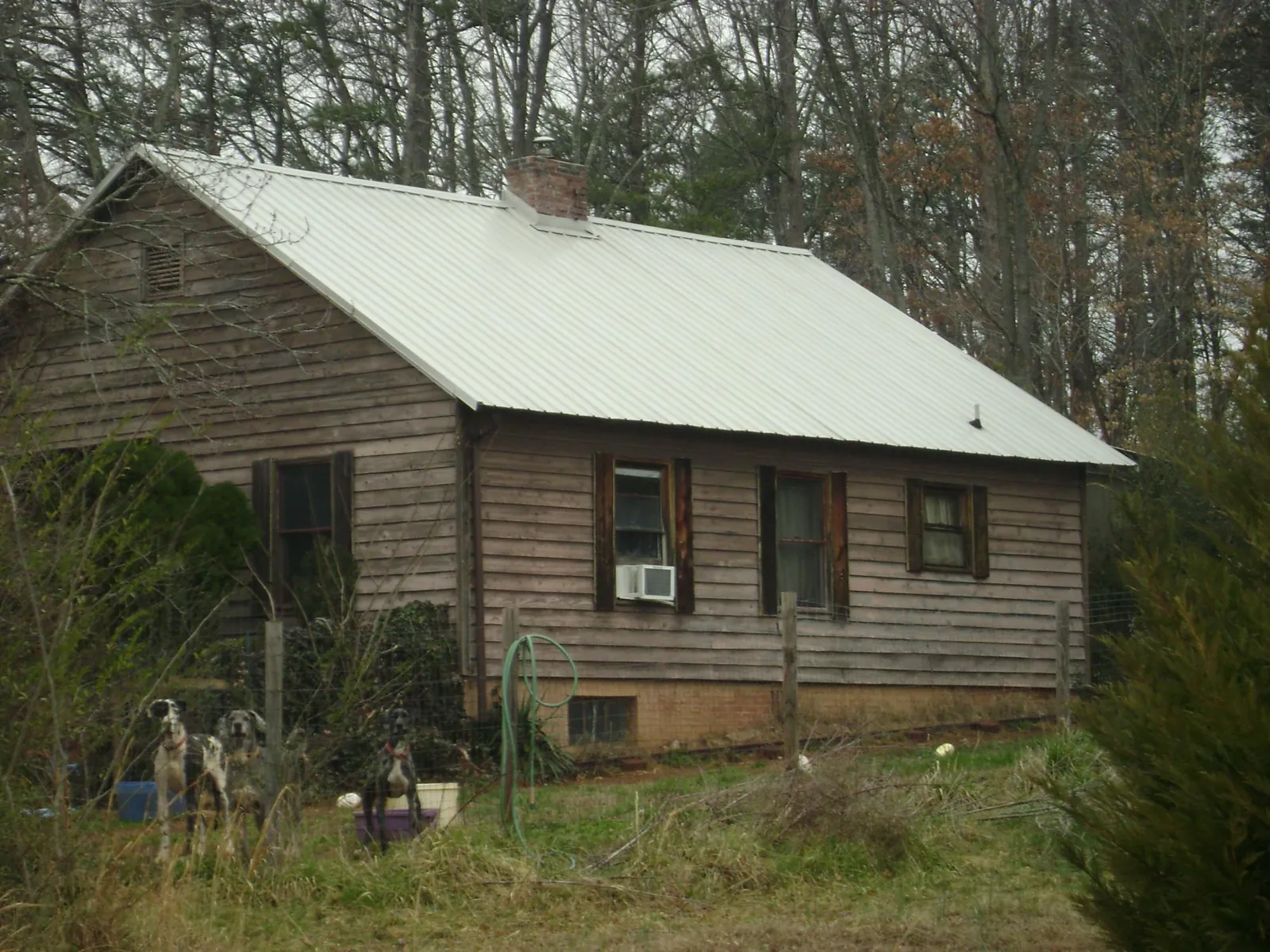 White metal roof on an old wood sided farmhouse, from a Metal Roof Installation job in Otter Creek